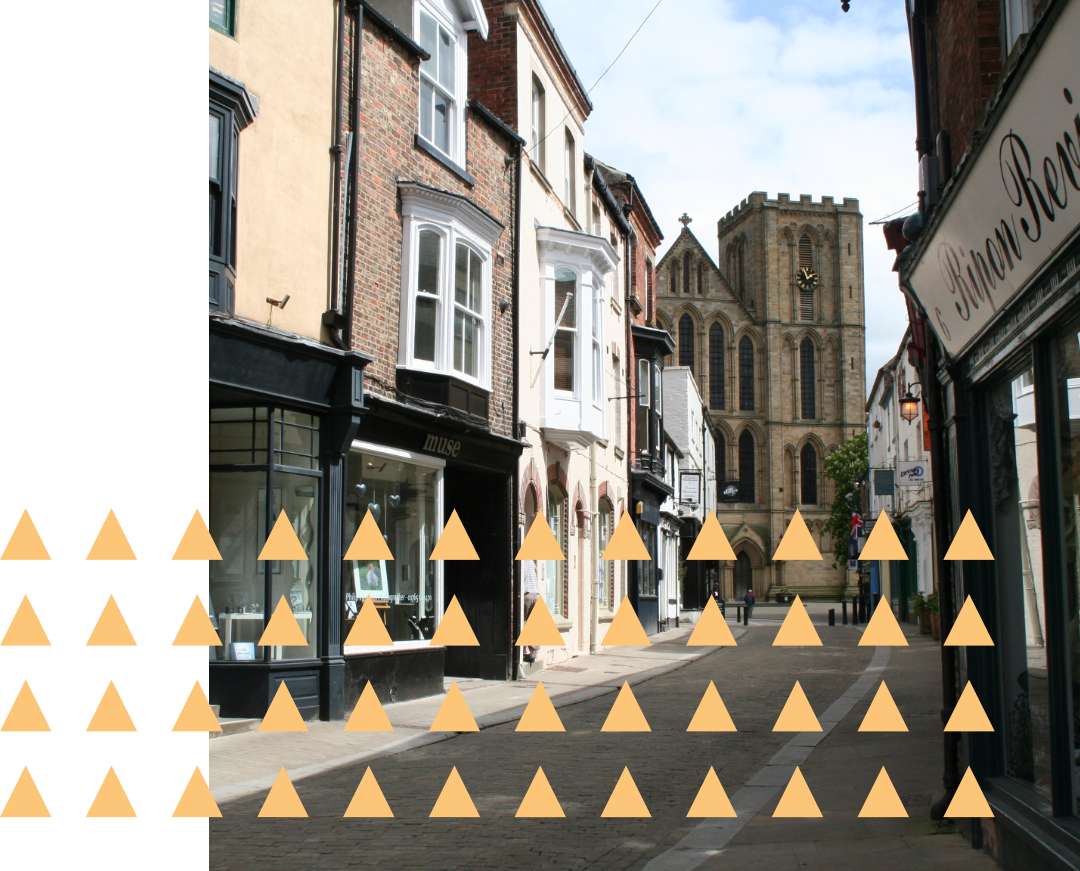 Ripon Cathedral with a row of shops in the foreground.
